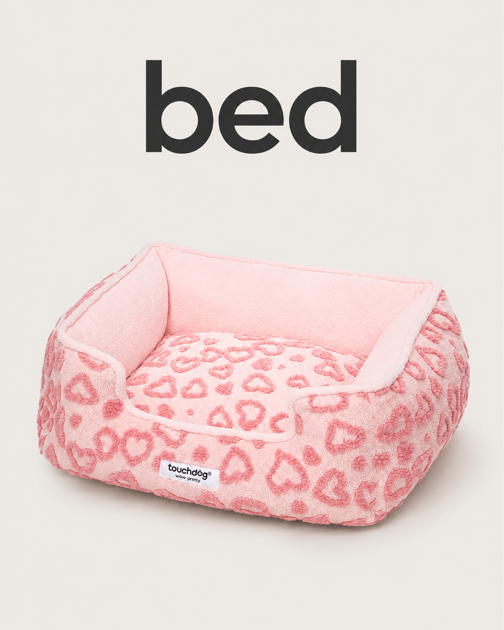 Pink plush pet bed with raised sides and heart pattern